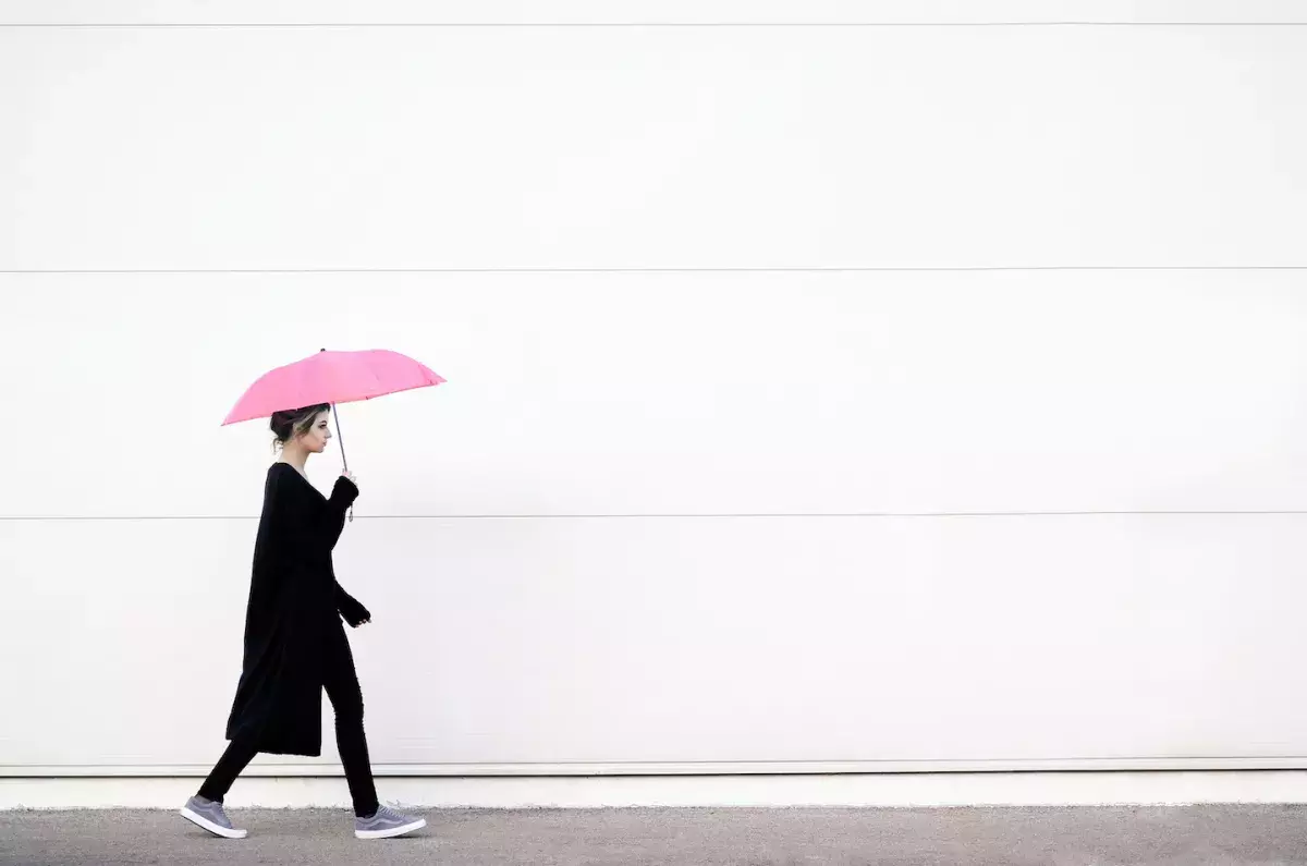 AdobeStock_136754314.jpeg person walking with unbrella