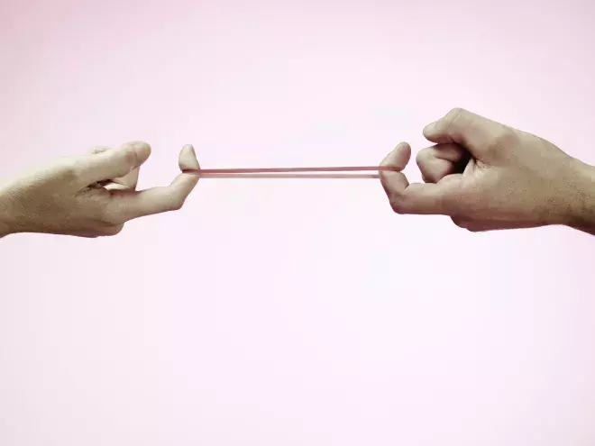 Fingers pulling a rubber band