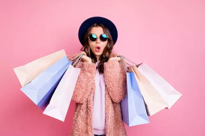 woman holding an excessive amount of shopping bags