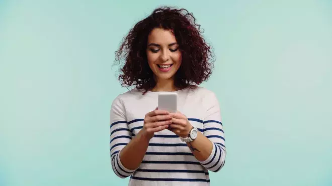 woman looking down at cell phone