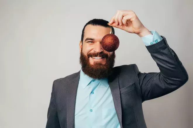 smiling man holding ornament up 