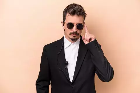 AdobeStock_489875196.jpeg undercover security person with sunglasses and ear piece