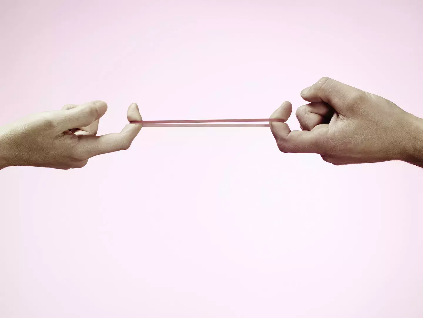 Fingers pulling a rubber band