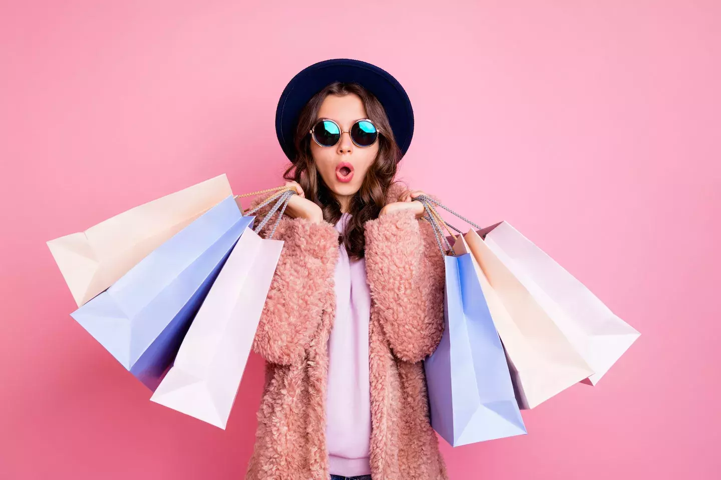 woman holding an excessive amount of shopping bags