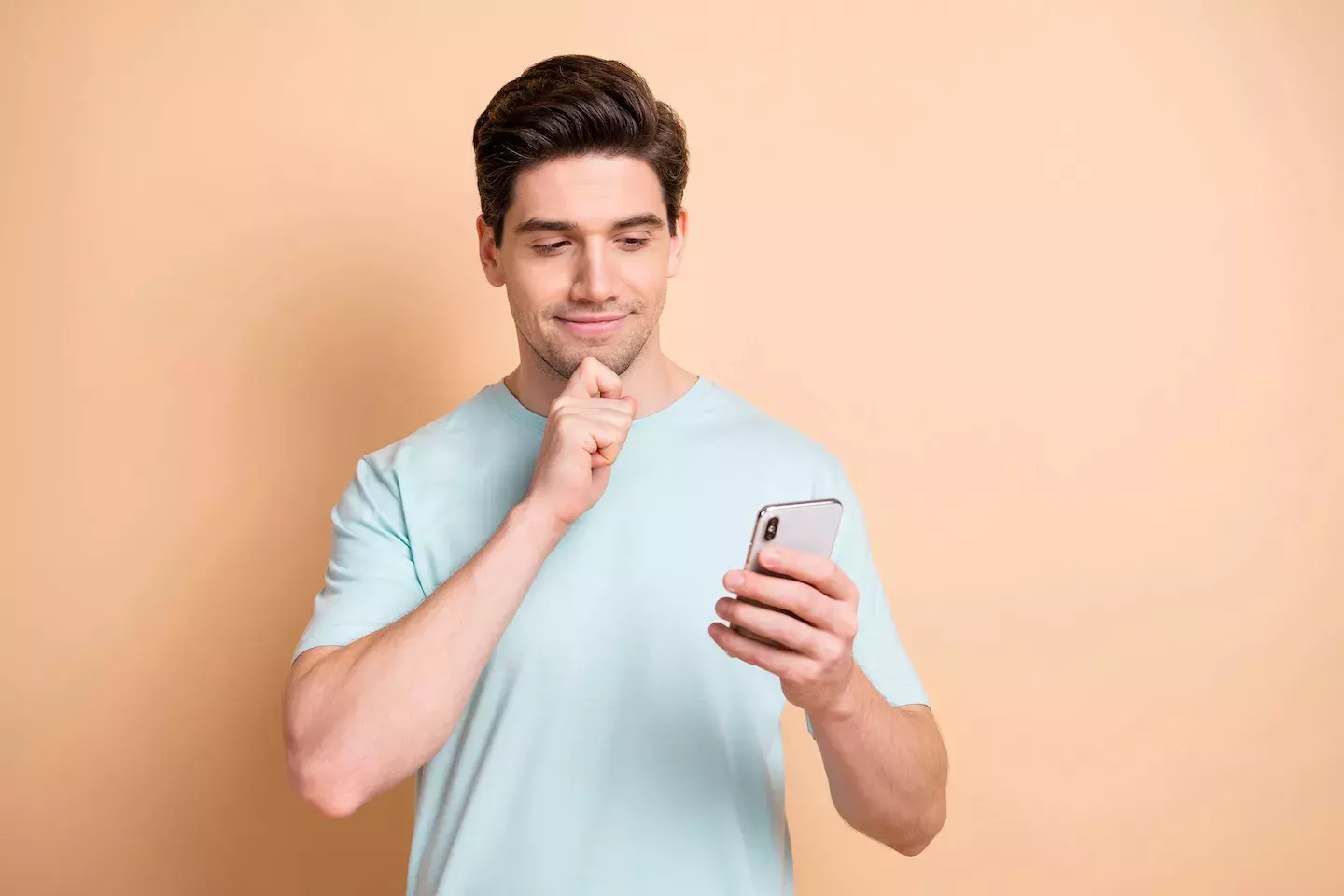 man looking at cell phone with questionable expression