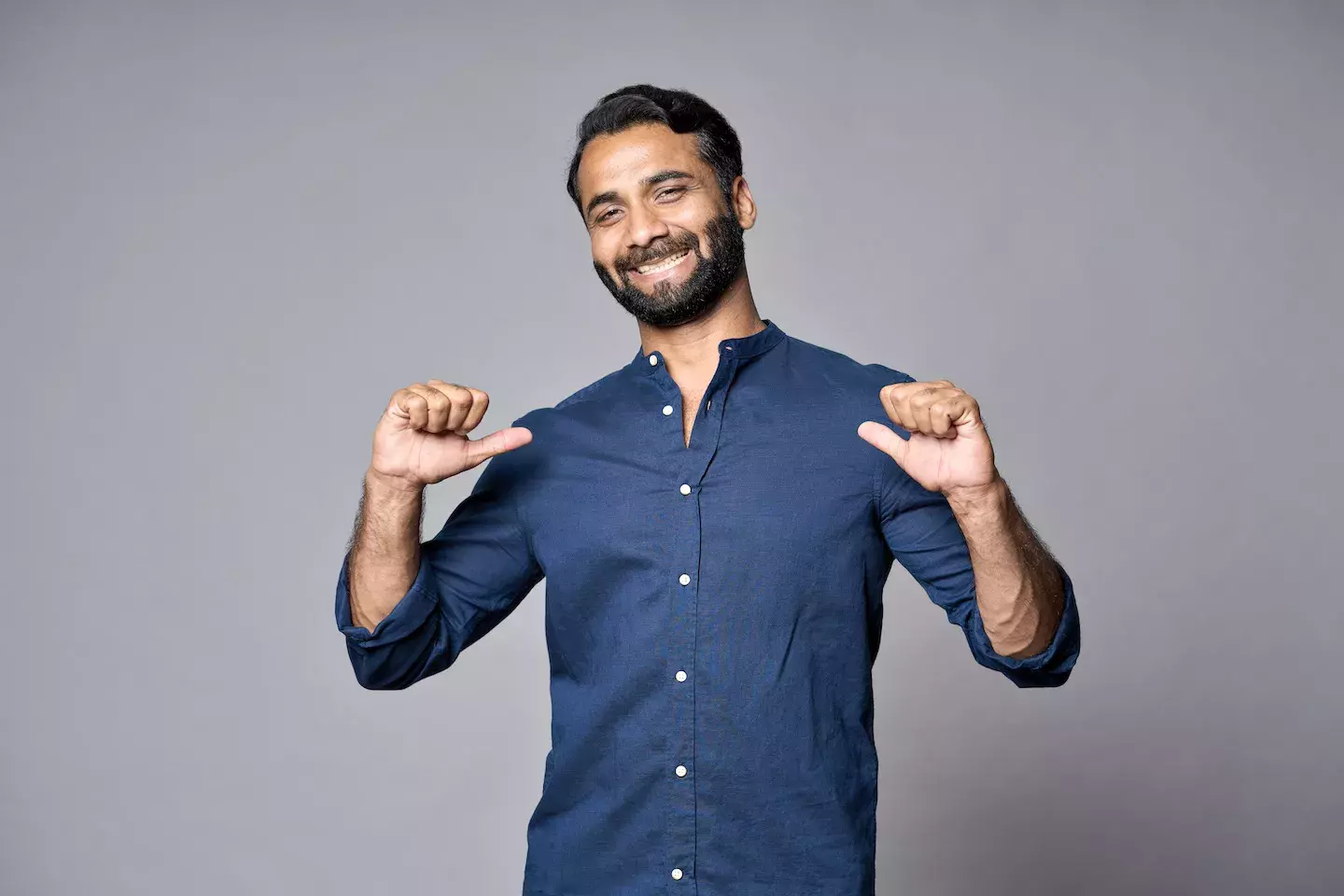 confident person smiling and pointing at self