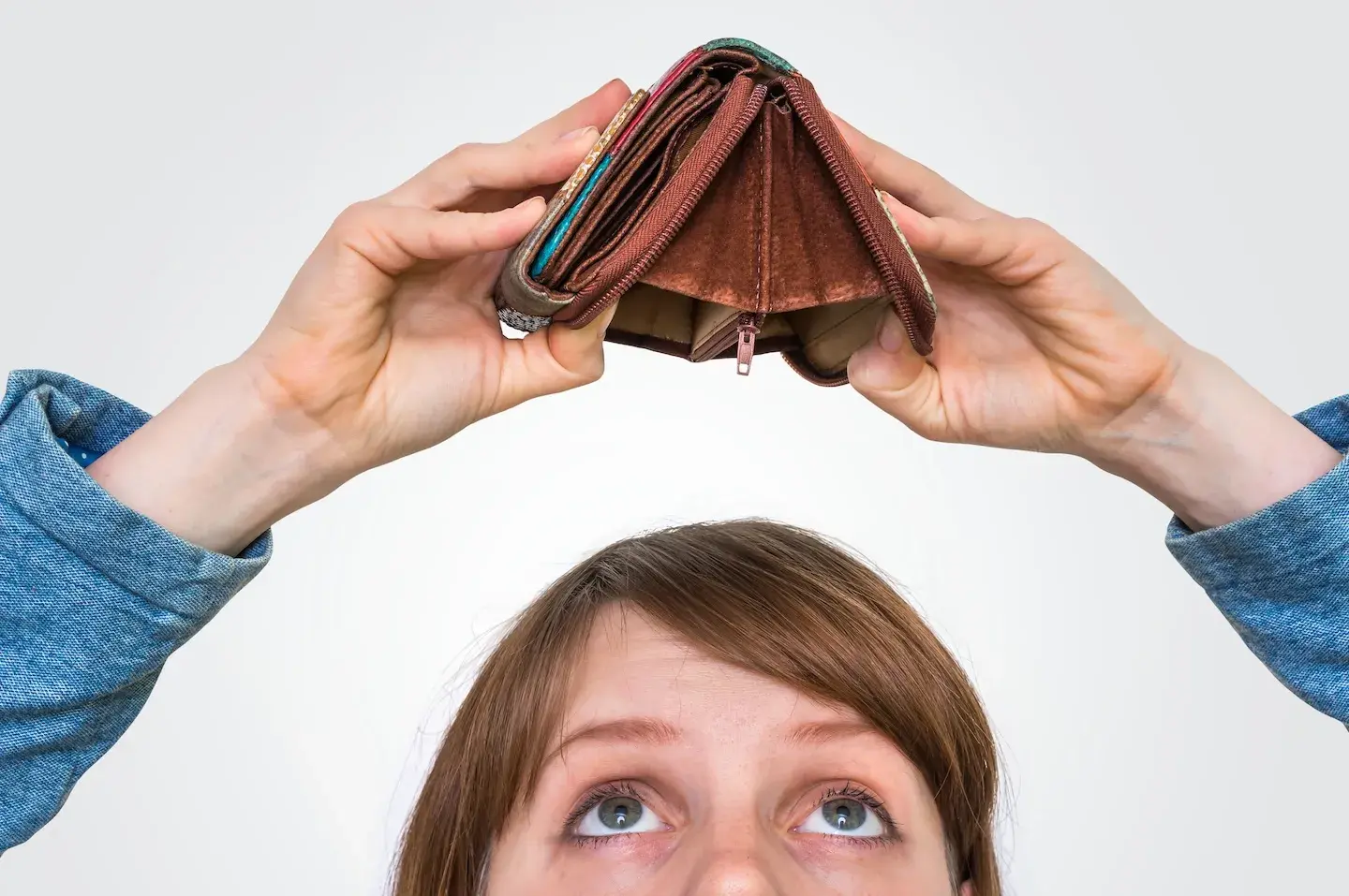 woman holding empty wallet above her head