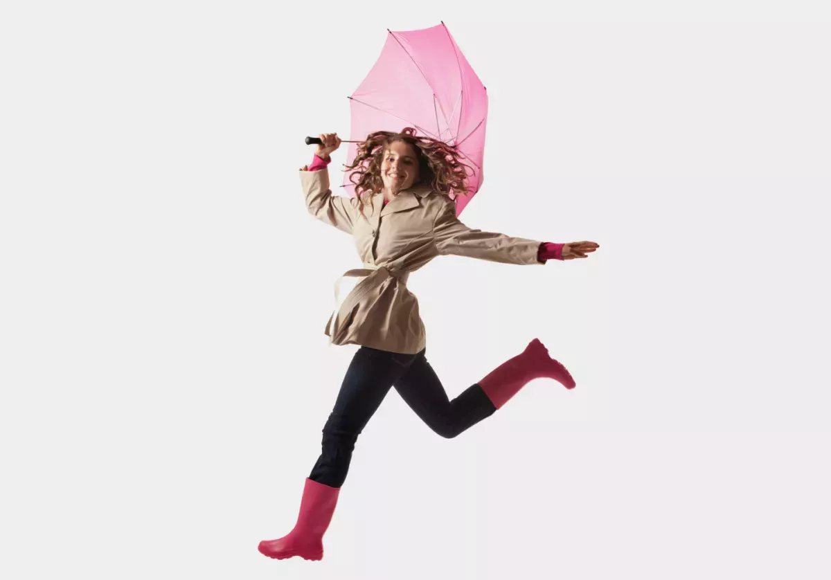 Mulher pulando com um guarda-chuva