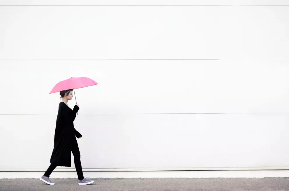 Mulher caminhando com unbrella rosa