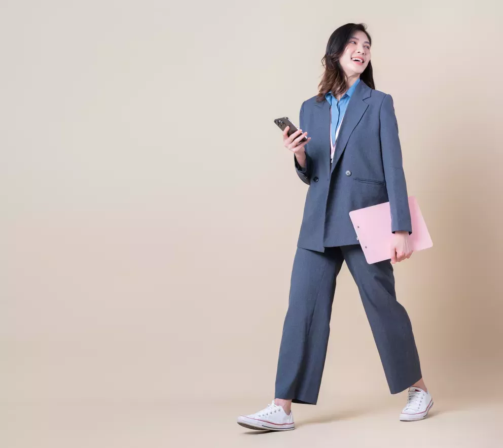 smiling person holding cellphone and clipboard