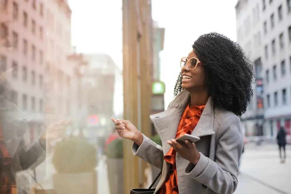Mulher sorridente vitrine de compras na cidade grande