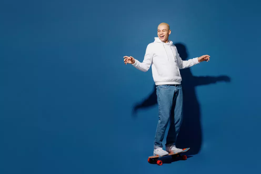 Homem sorridente se equilibrando no skate Homem sorridente se equilibrando no skate