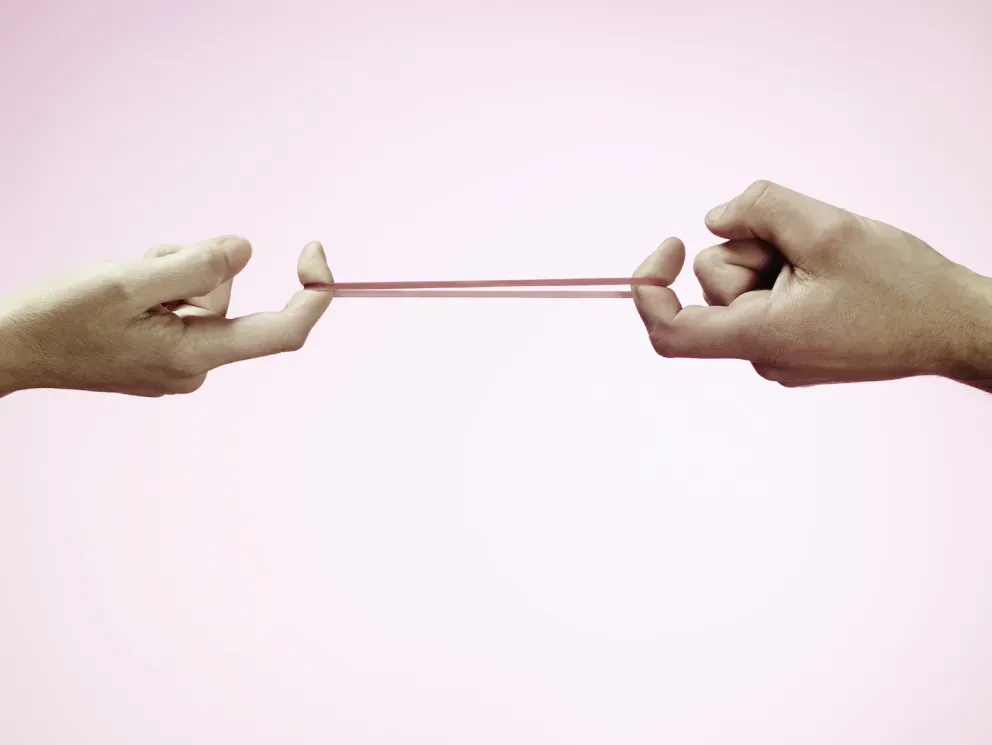 Fingers pulling a rubber band