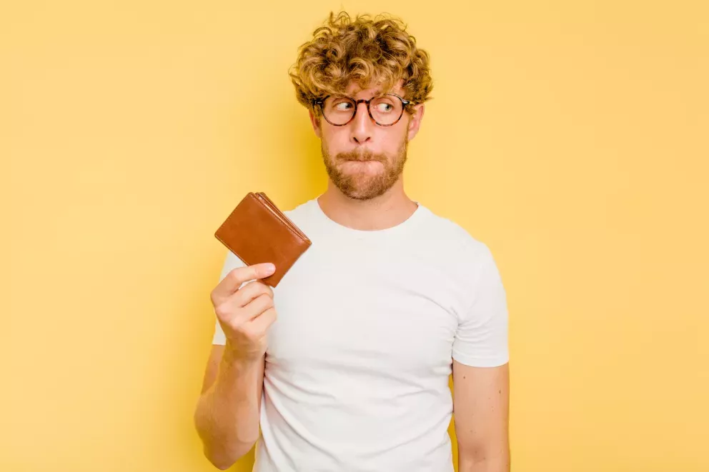 Homem preocupado segurando carteira