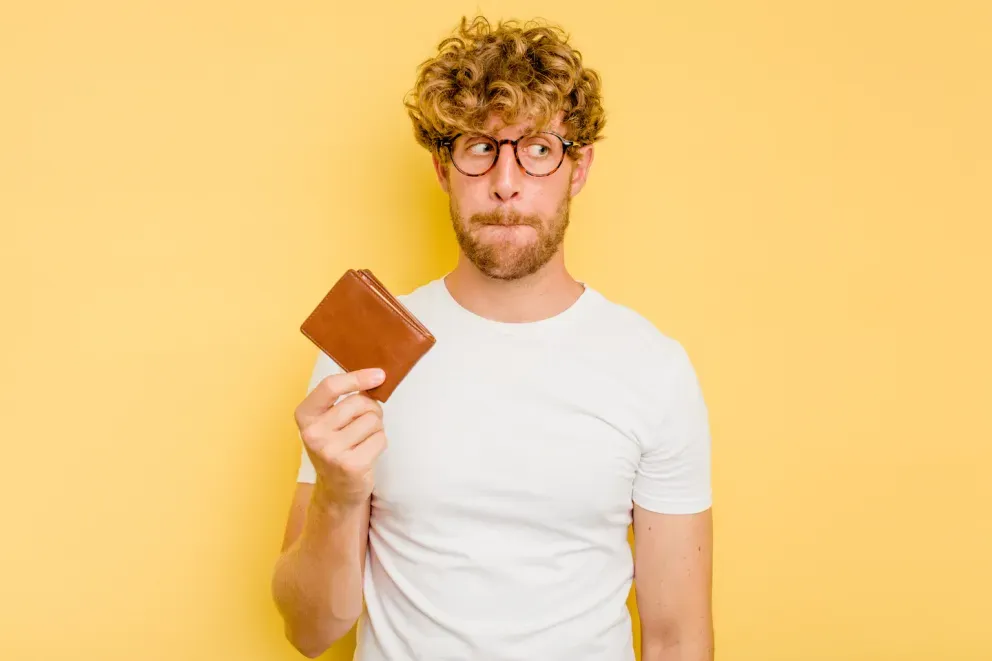 Homem preocupado segurando carteira