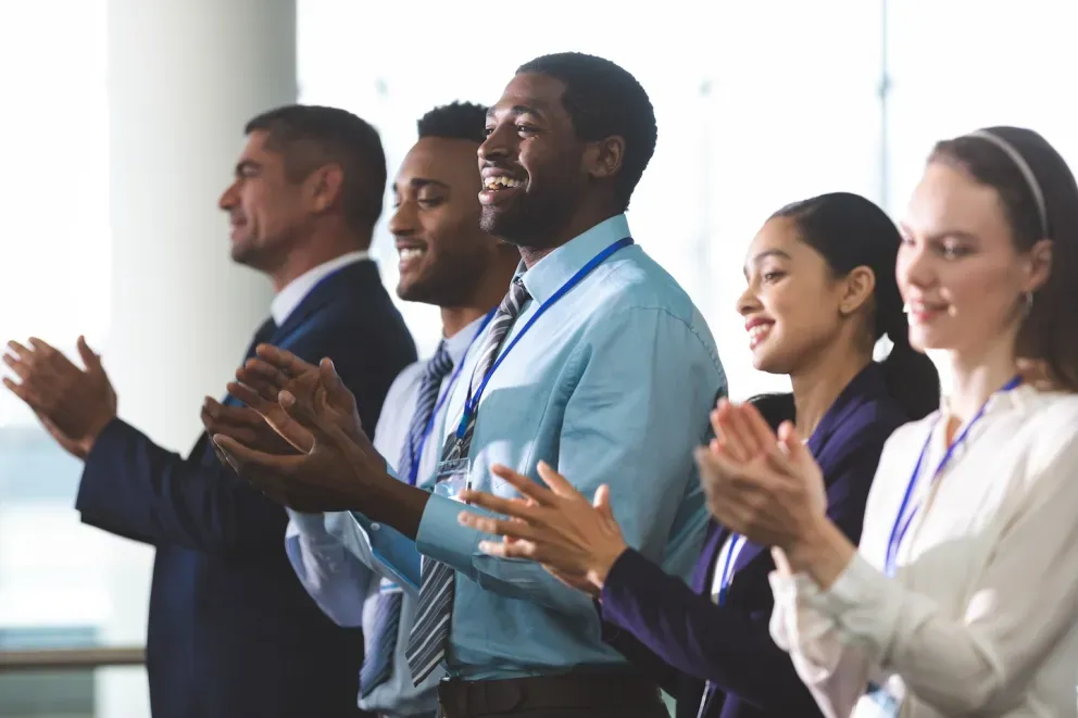 Grupo de colegas de trabalho batendo palmas em convenção