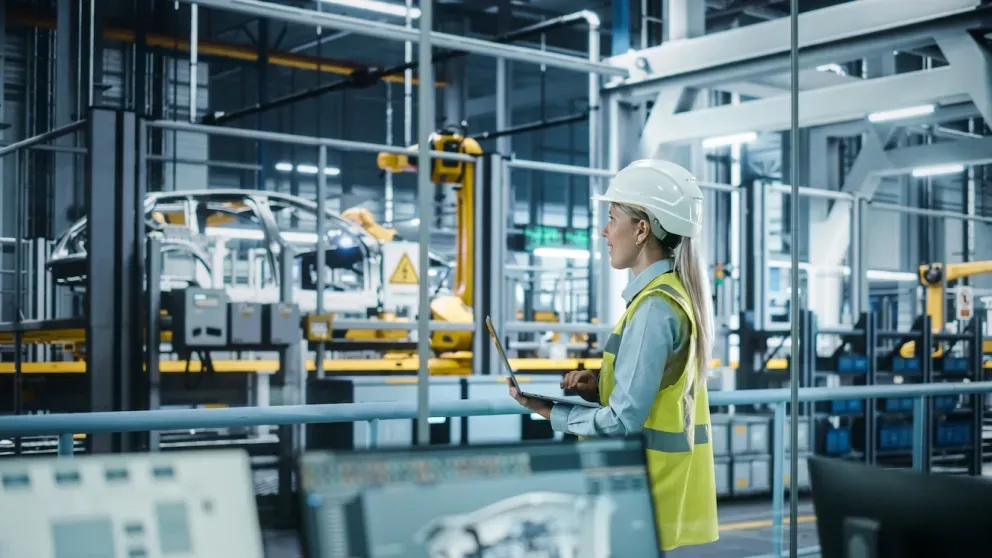 engenheiro olhando para a fábrica de produção de automóveis