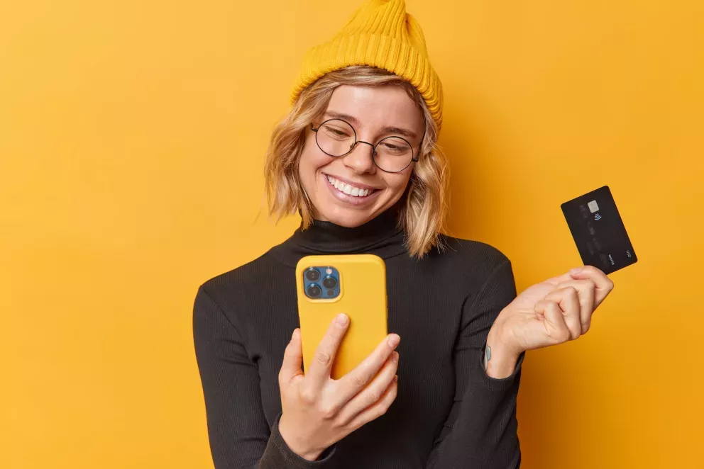Mulher com telefone e cartão Mulher com telefone e cartão