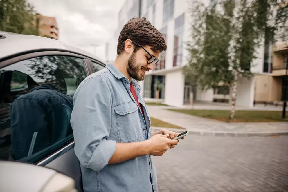 Homem com telefone e carro