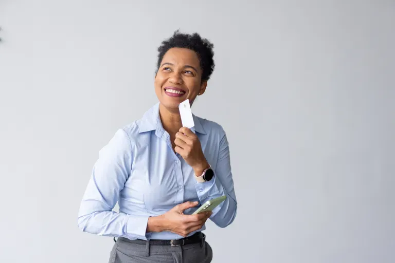 Mulher sorridente com telefone e cartão Mulher sorridente com telefone e cartão
