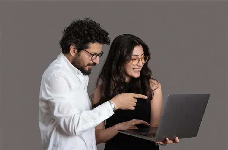 Two people staring at a laptop together