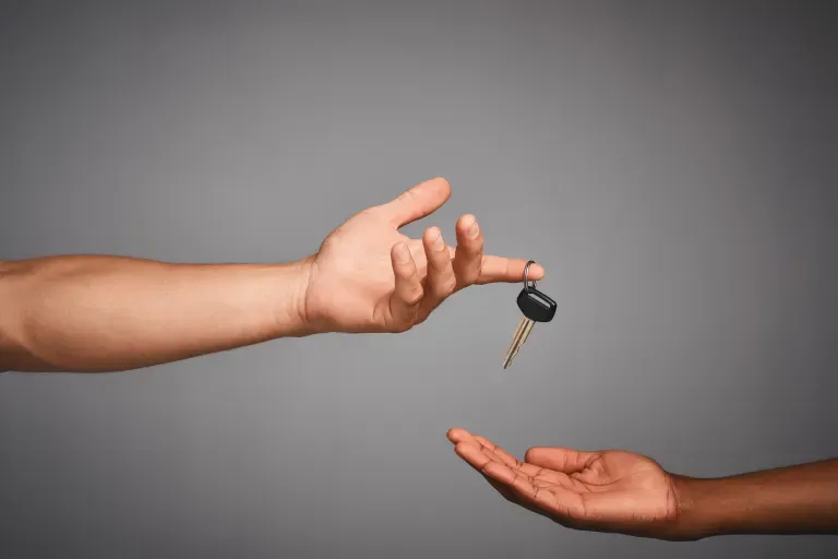 Two hands passing keys