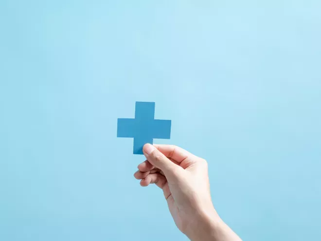 Person holding a cross symbol for medicine Person holding a cross symbol for medicine