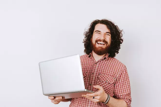 Homem sorridente segurando laptop