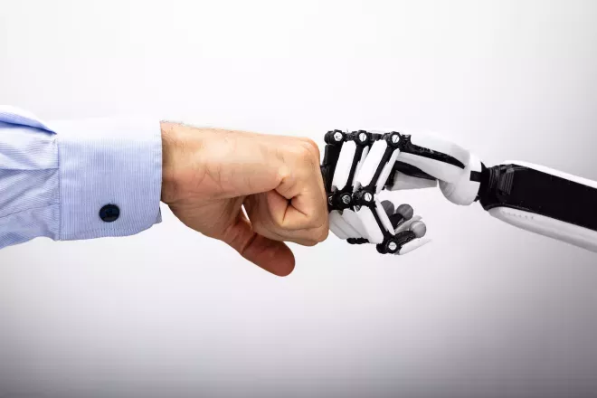 mão humana e mão robô batendo punhos