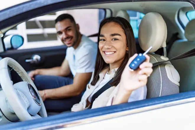 Casal dirigindo carro novo