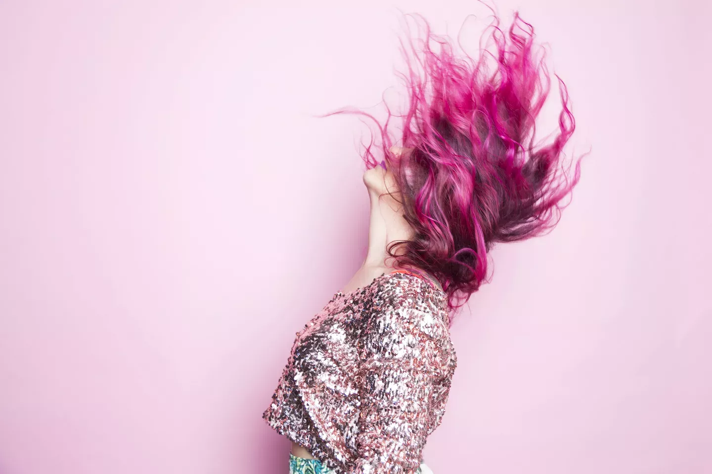 Mulher com cabelo rosa virando-o para trás