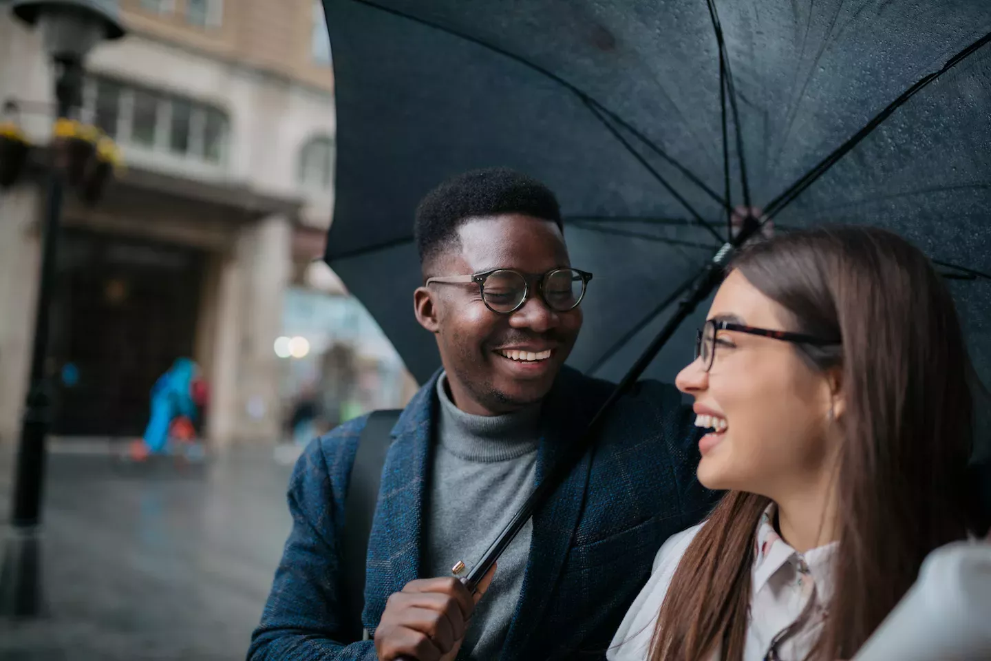 Homem protegendo uma mulher sob um guarda-chuva