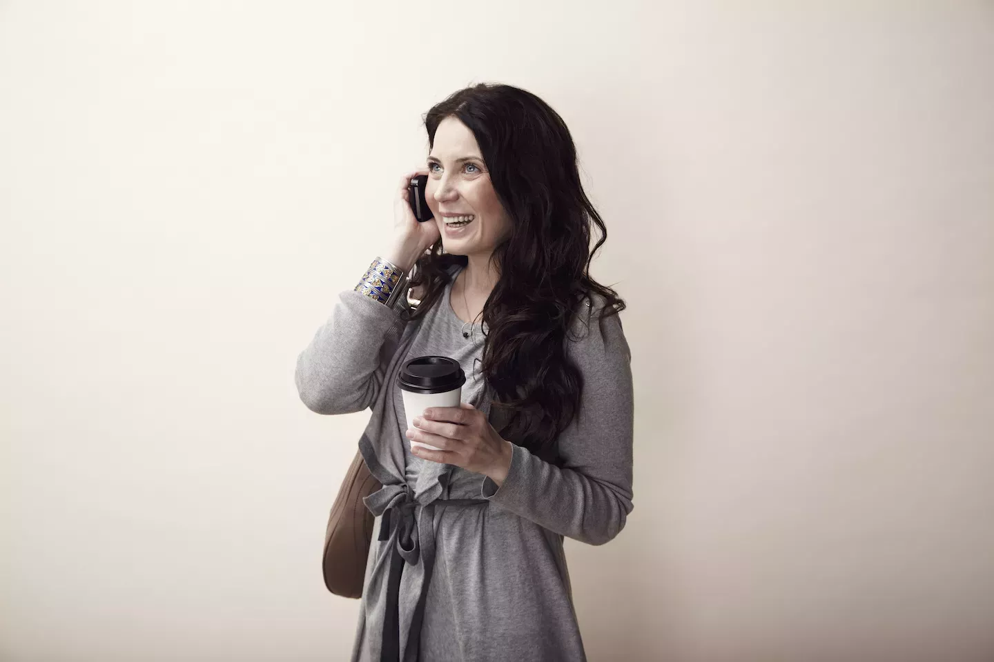 falar ao telefone segurando café