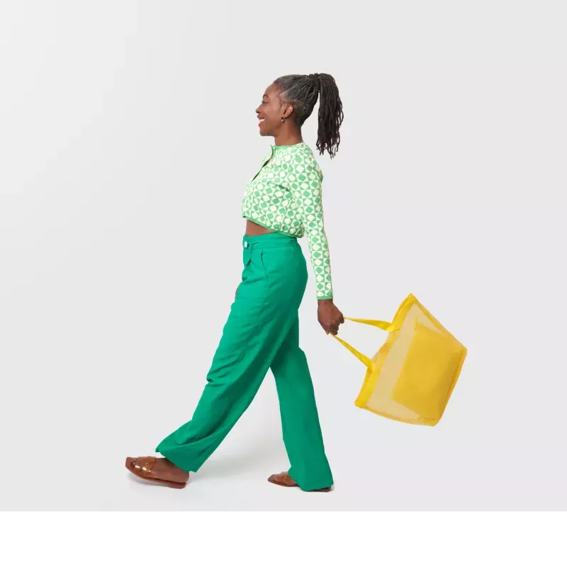 Mulher caminhando com um saco de compras