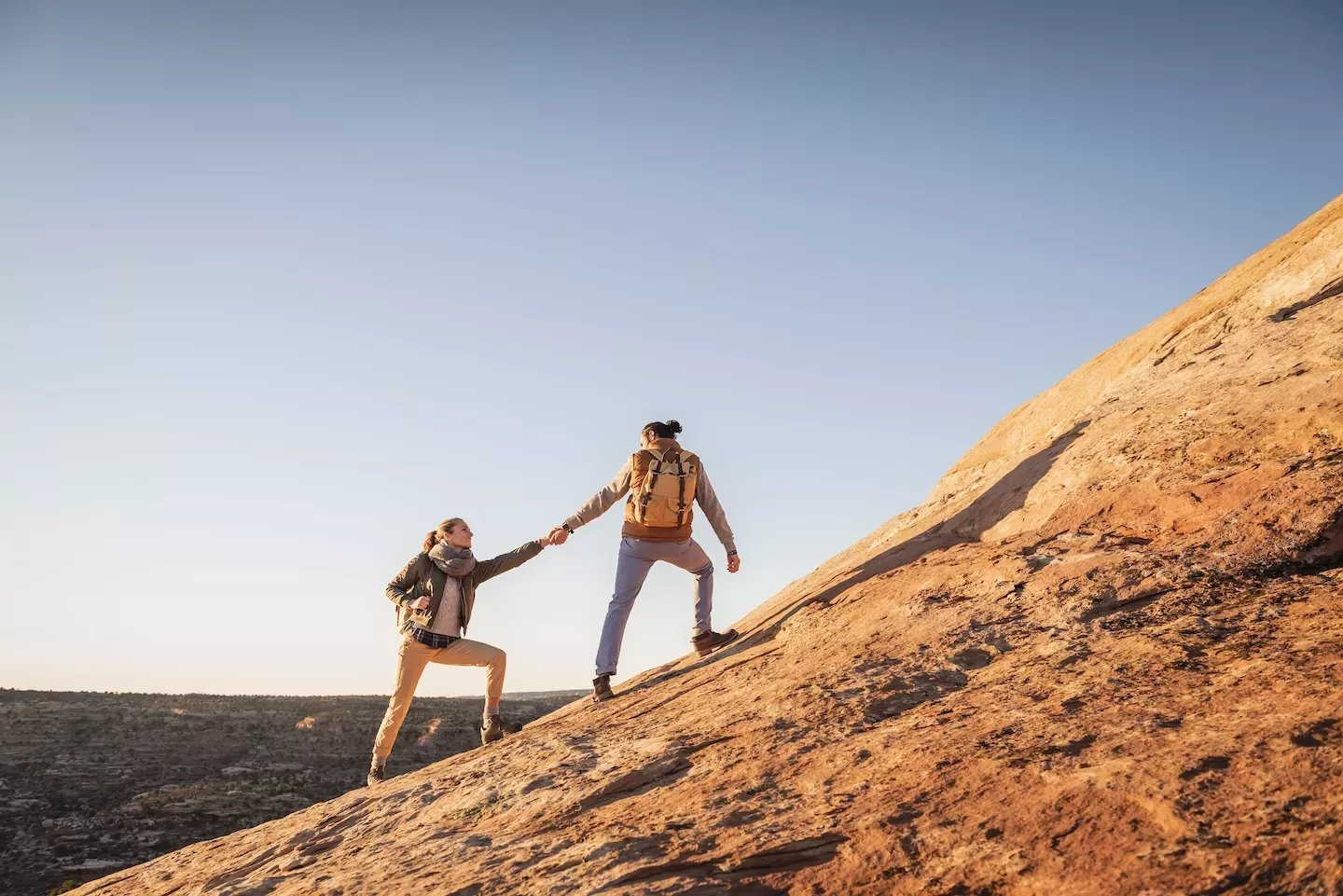 Hiker reaching hand out to other hiker Hiker reaching hand out to other hiker