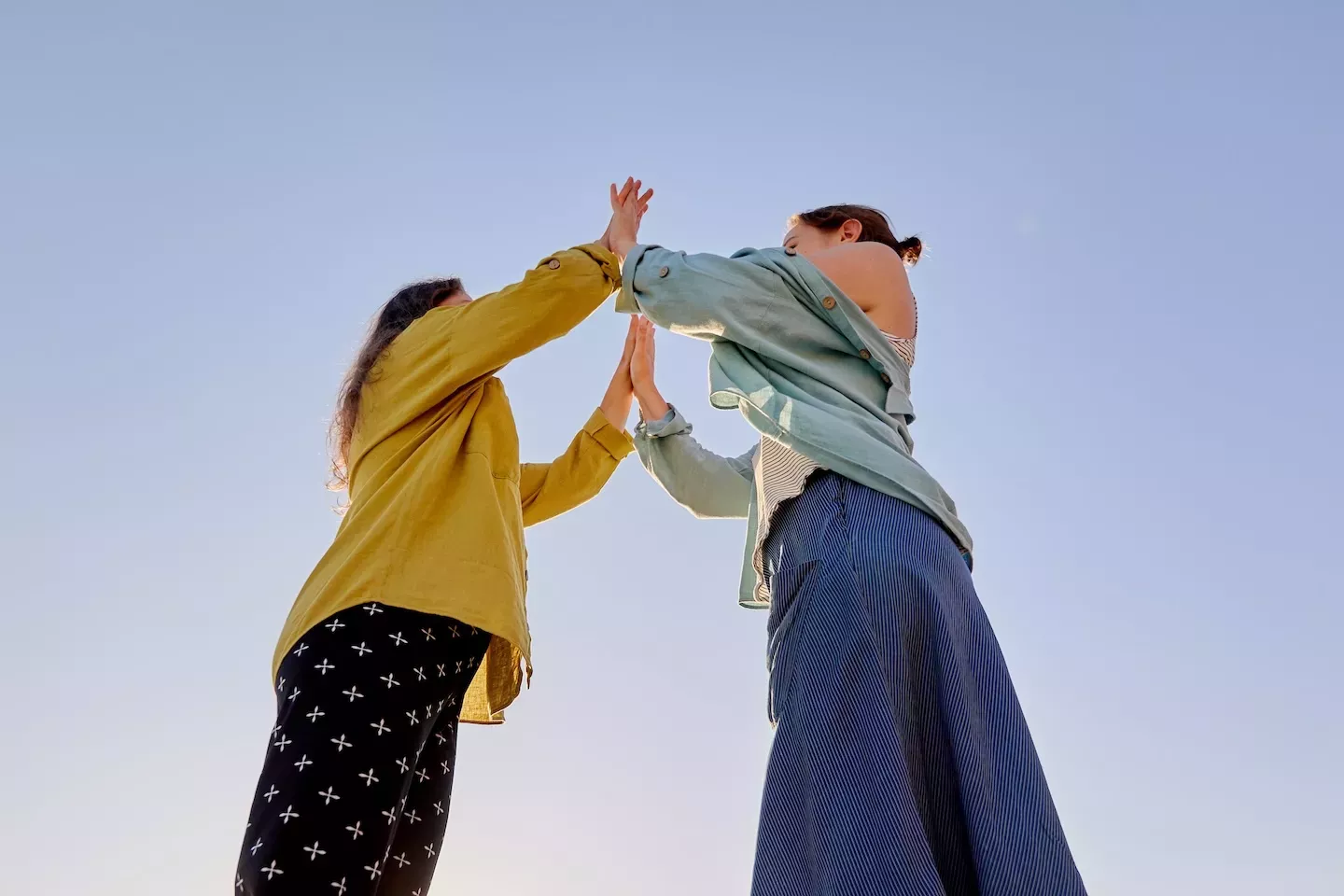 Two people high-fiving Two people high-fiving