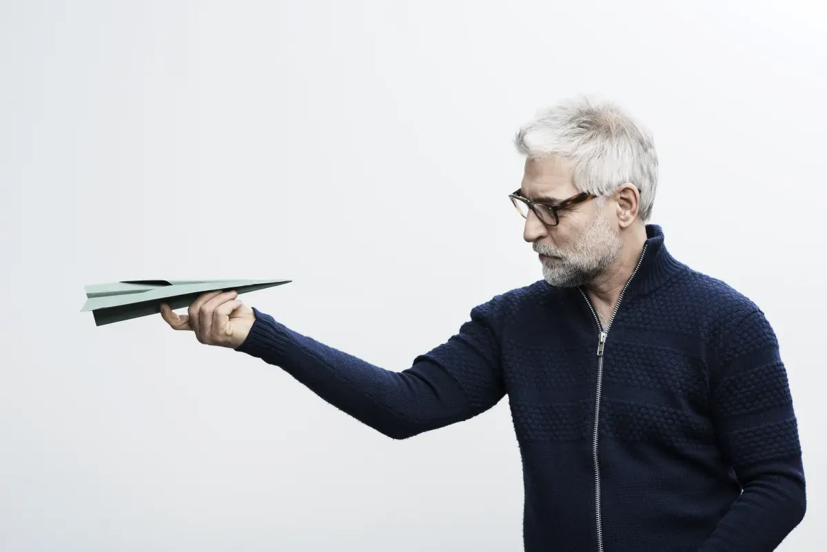Mann schaut auf Papierflieger