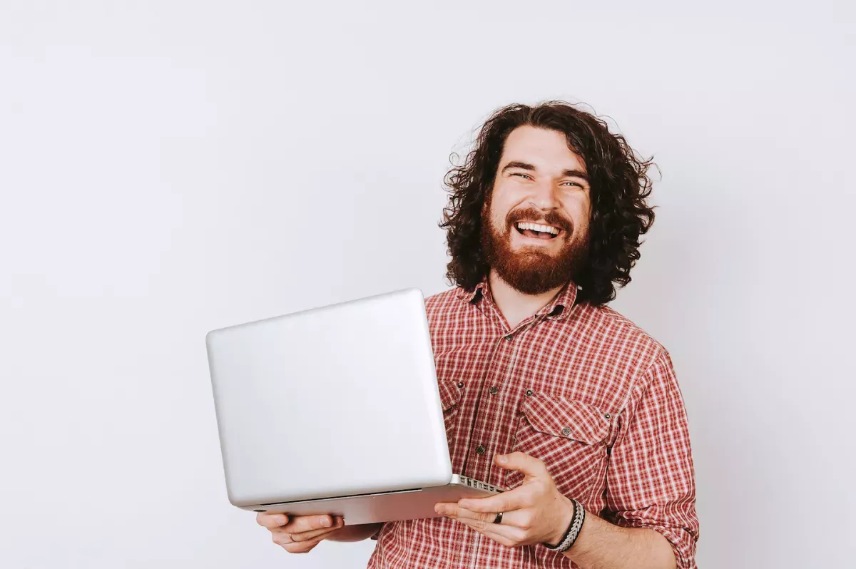Lächelnder Mann mit Laptop in der Hand