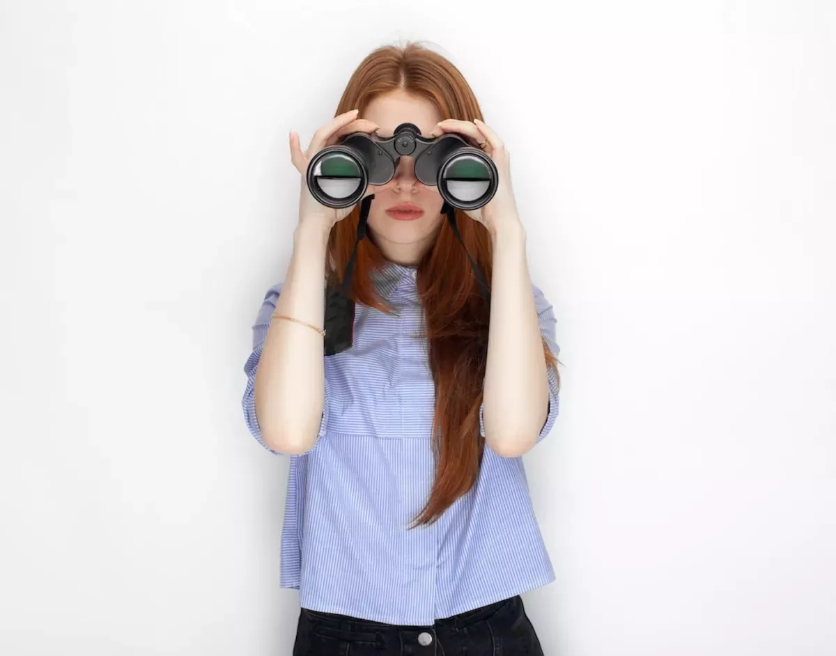 Frau schaut durch ein Fernglas Frau schaut durch ein Fernglas