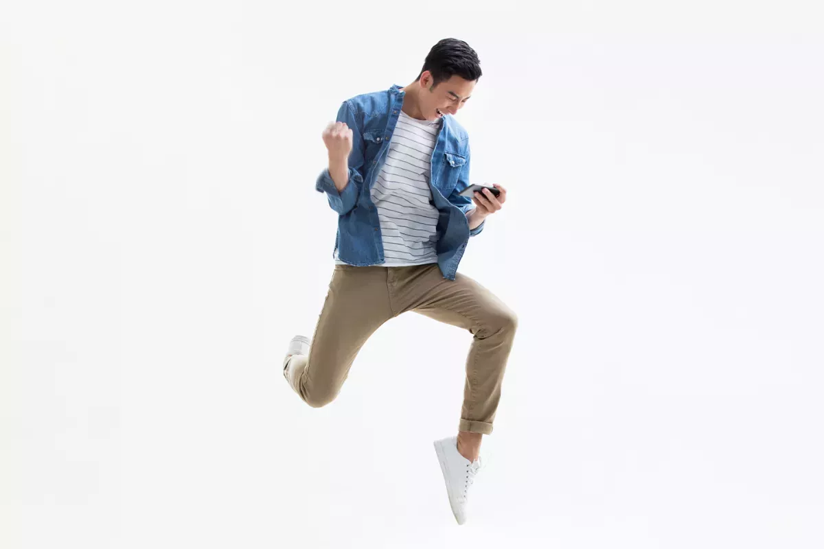 Person, die springt und schaut auf das Telefon