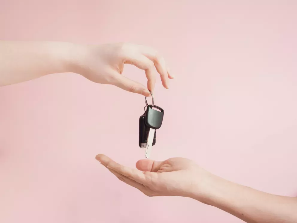 Person, die einer anderen Person Schlüssel übergibt