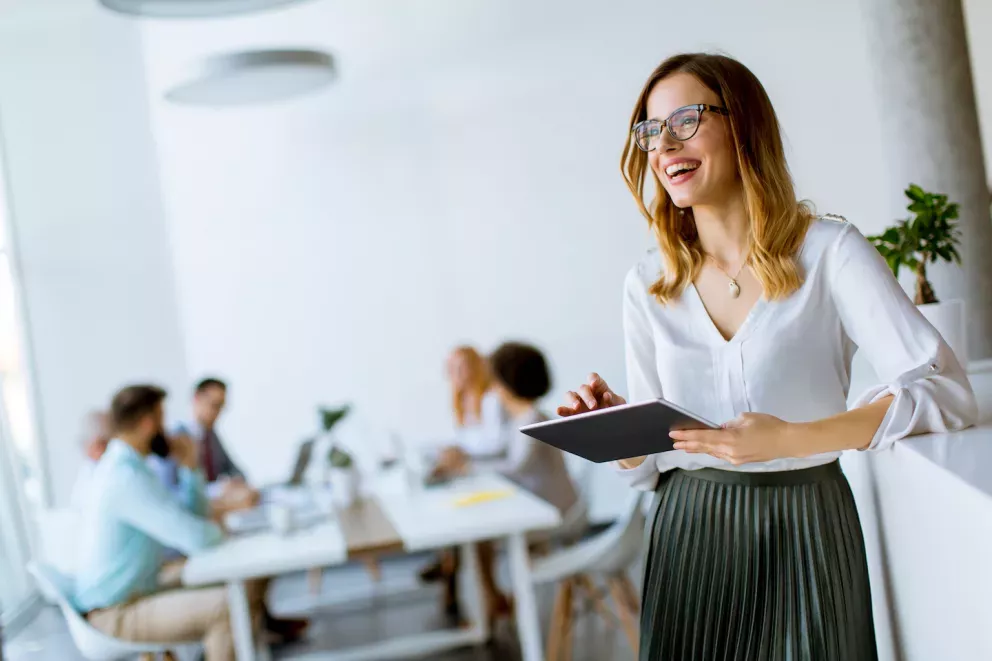 Frau arbeitet in einem Büro und lächelt Frau arbeitet in einem Büro und lächelt