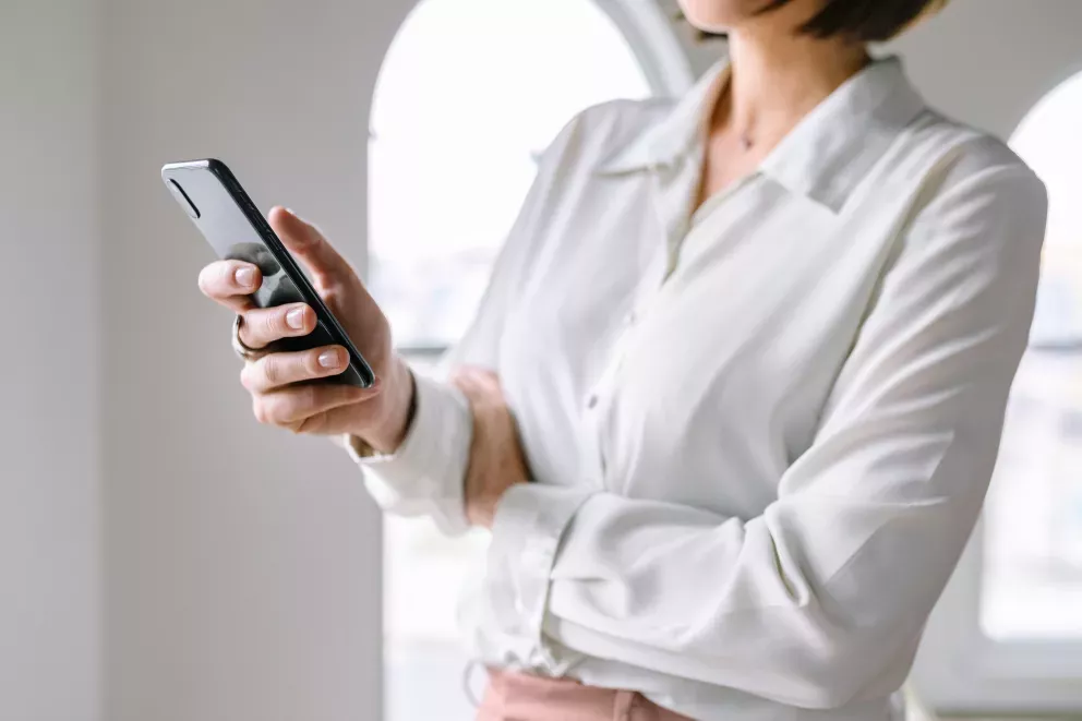 Nahaufnahme einer Person, die ein Mobiltelefon benutzt