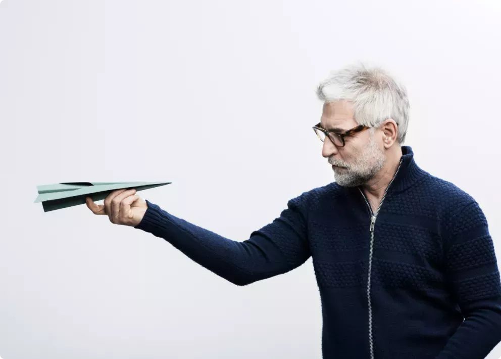 Mann schaut auf ein Papierflugzeug Mann schaut auf ein Papierflugzeug