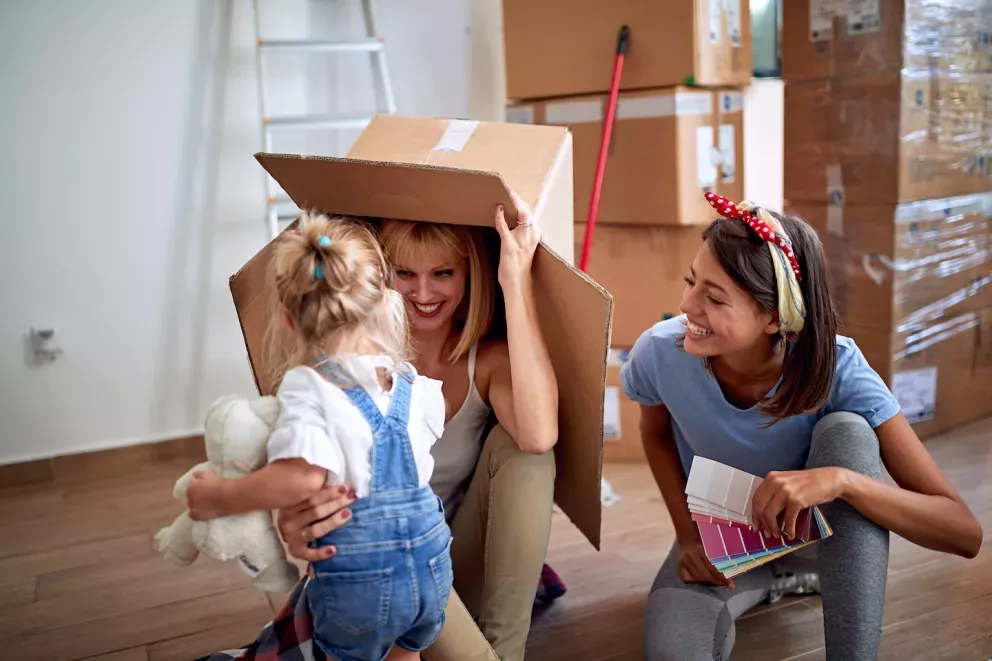 Paar spielt mit Kleinkind und Umzugskarton couple playing with toddler and moving box