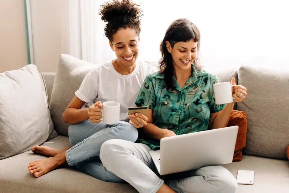 smiling couple on computer with new credit card