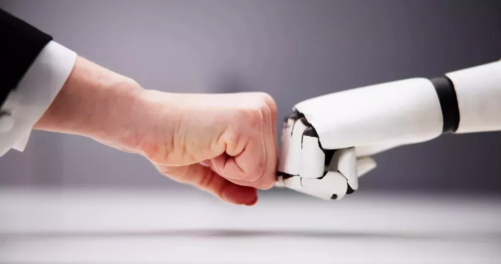 Fist Bump mit menschlicher Hand und Roboterhand Fist Bump mit menschlicher Hand und Roboterhand