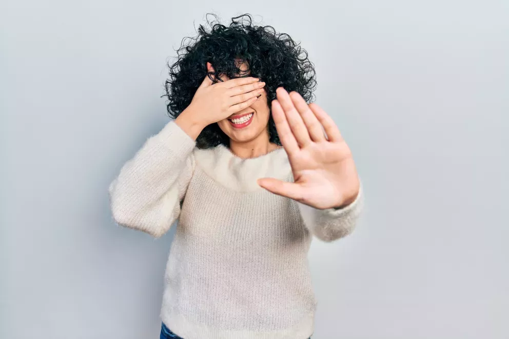(Abbildung: Frau mit der Hand über dem Gesicht)