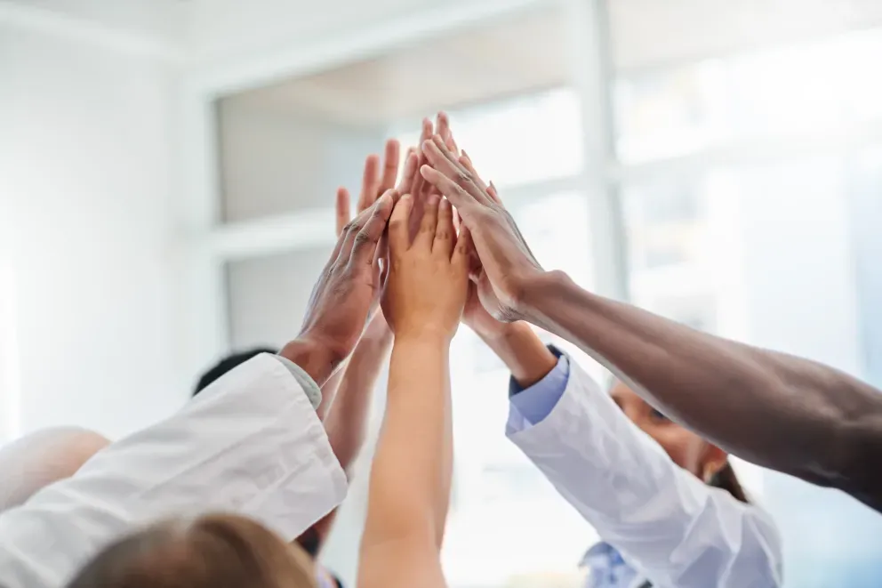 Vielfältige Gruppe von Menschen, die sich in einer Teamwork-Geste die Hände reichen. Vielfältige Gruppe von Menschen, die sich in einer Teamwork-Geste die Hände reichen.