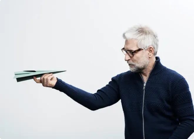 Mann schaut auf ein Papierflugzeug Mann schaut auf ein Papierflugzeug